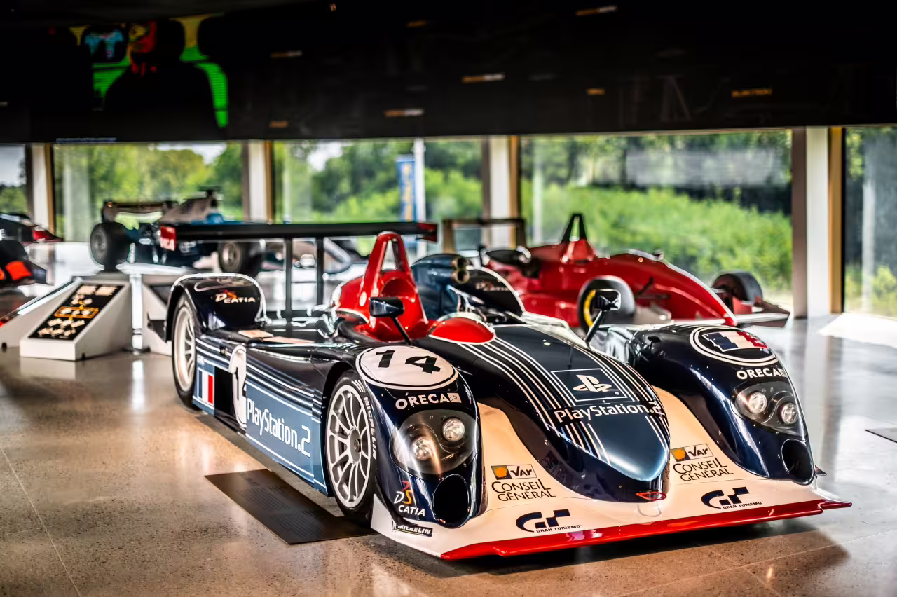 Admire the sleek design of a PlayStation-themed race car on display at Dallara Academy, celebrating racing innovation.