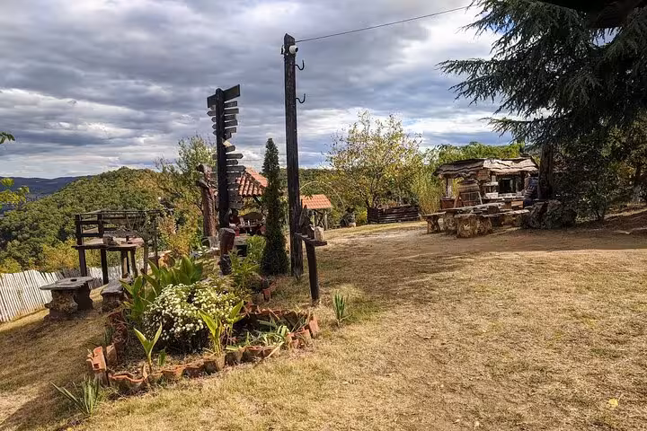 Rustic outdoor seating area with wooden furniture and lush greenery, offering a serene spot along the Danube day trip route.