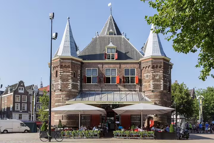 De Waag historic building with outdoor restaurant seating on Nieuwmarkt square in Amsterdam