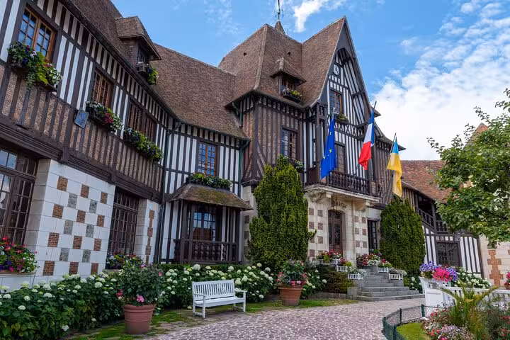Historic half-timbered building with colorful flowers and European flags in Deauville, France