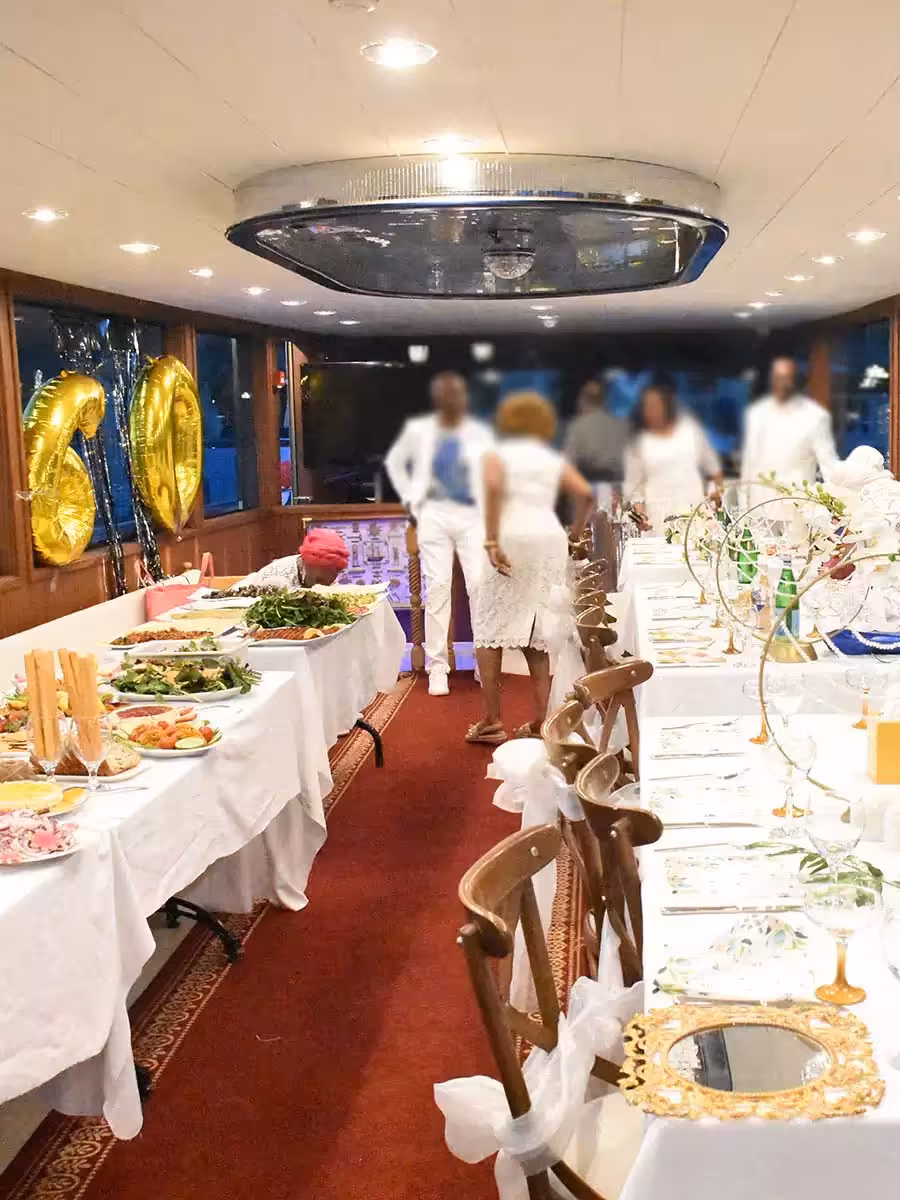 Decorated yacht dining room with buffet and 60th birthday balloons, ideal private birthday party boat rental