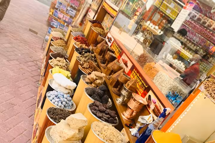 Deira Spice Souk stalls with aromatic herbs and dried fruits, Old Dubai souks on private city tour