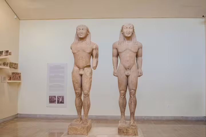 Archaic Greek kouros statues inside Delphi Archaeological Museum, cultural highlight on Delphi day trip tour