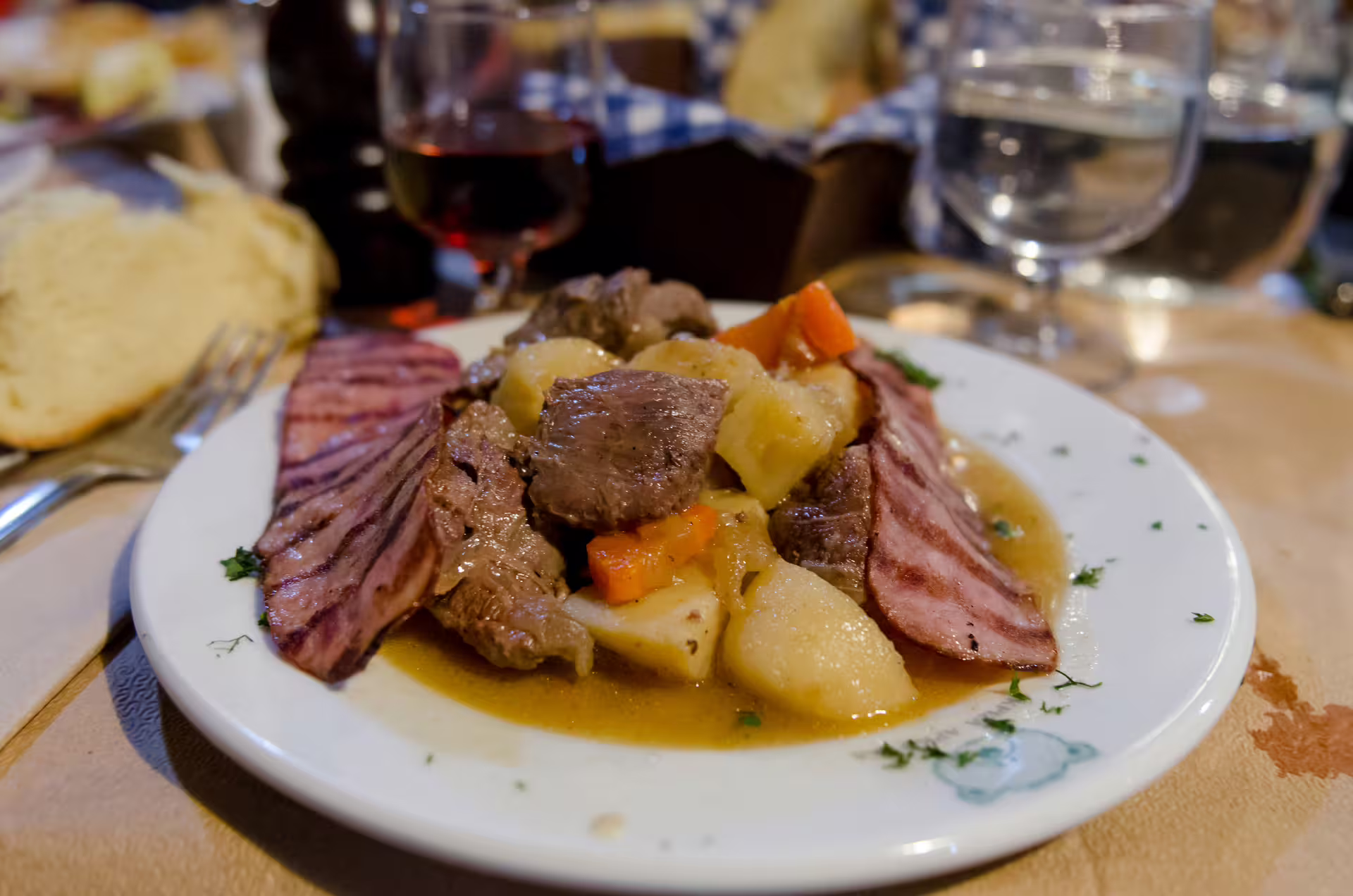 Traditional Greek lunch stop on Delphi small group day tour from Athens, hearty stew with wine and bread