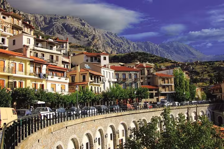 Delphi mountain town with stone bridge and red-roof houses, scenic drive on Meteora and Delphi 2-day private trip
