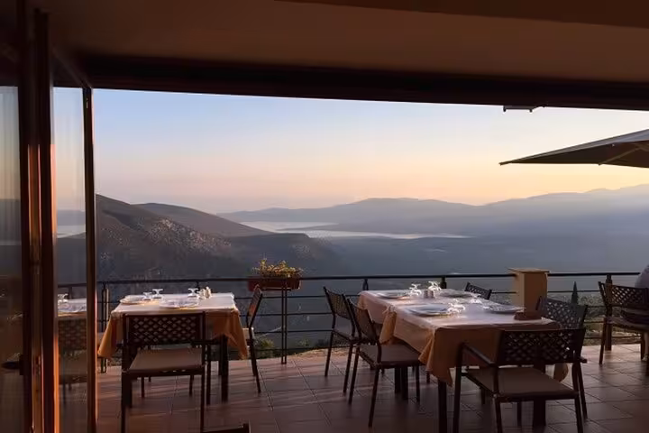 Scenic dining terrace overlooking Delphi's majestic mountains at sunset, perfect for enjoying the Discover Delphi tour.