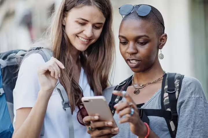 Travelers using a smartphone GPS app for a self-guided walking tour of Den Haag highlights