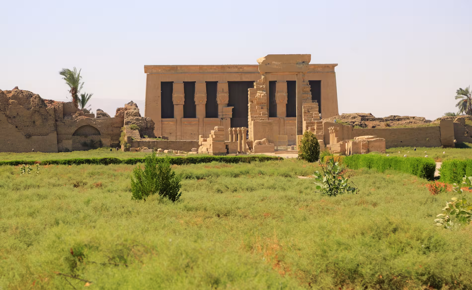 Panoramic exterior view of Dendera Temple complex surrounded by lush greenery on full-day tour from Safaga