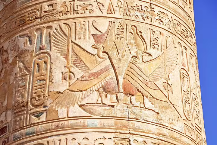 Dendera Temple of Hathor column relief with winged sun disk and hieroglyphs on day trip from Luxor