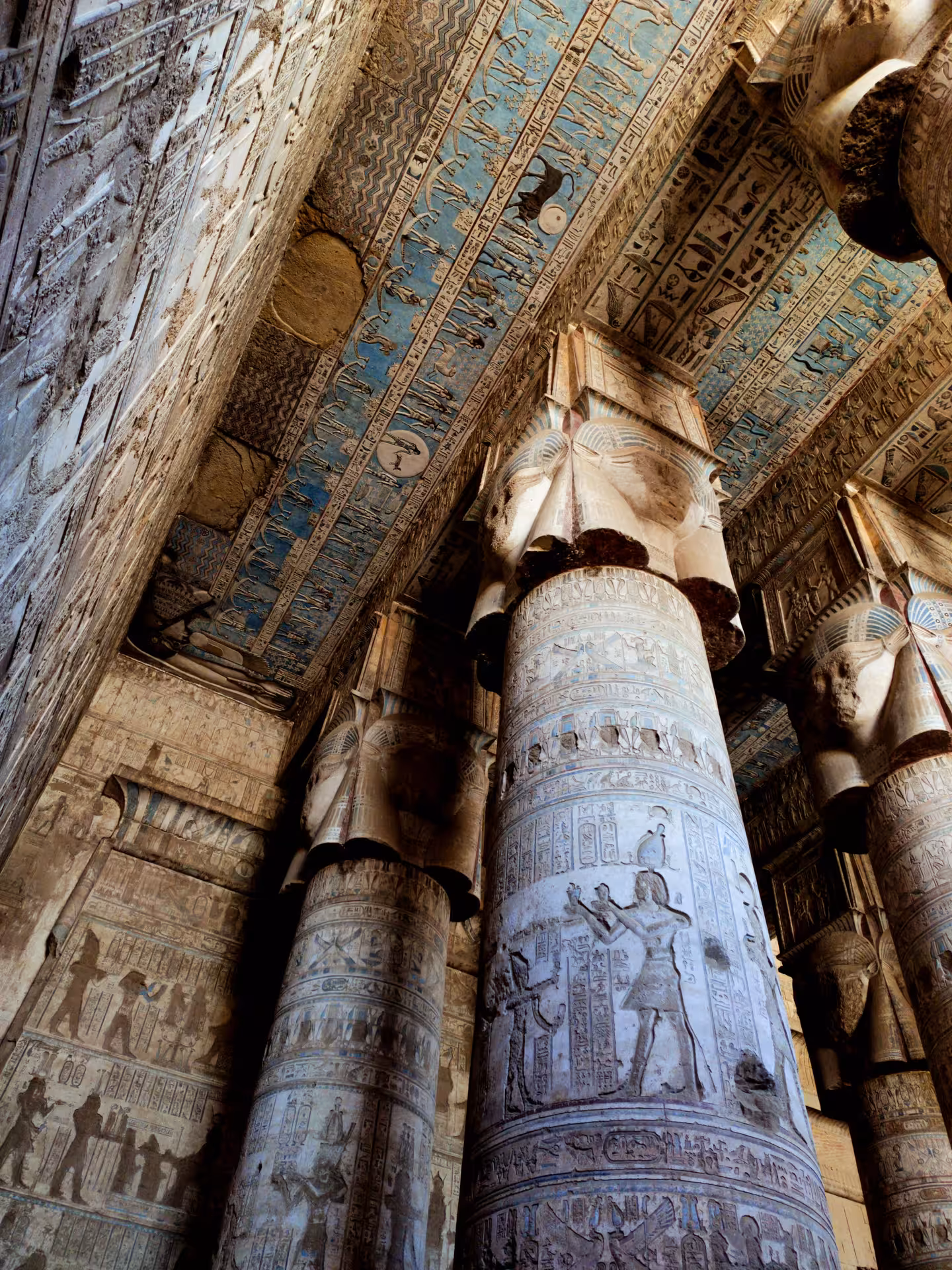 Ornate Hathor-headed columns with vivid hieroglyphic ceiling inside Dendera Temple on a Safaga full-day tour