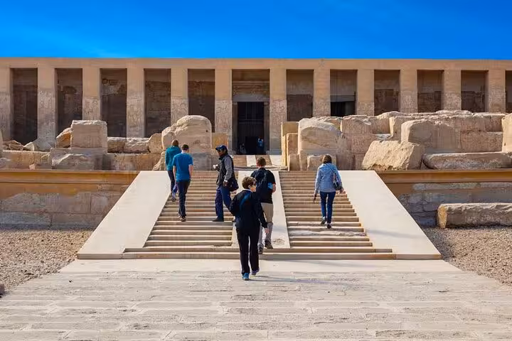 Travelers climbing steps to Dendera Temple entrance on a private day tour from Luxor to Dendera and Abydos