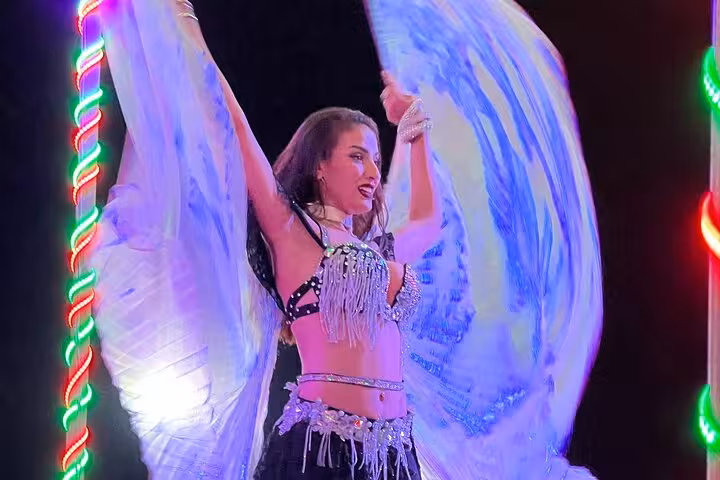 Belly dancer show at Ras Al Khaimah desert safari camp with dinner, colorful lights and wing dance