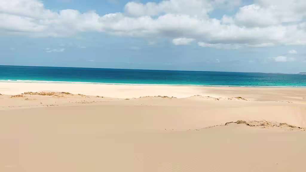 Vast sandy dunes leading to crystal-clear ocean waters at Desert of Viana, Boa Vista, Cape Verde.