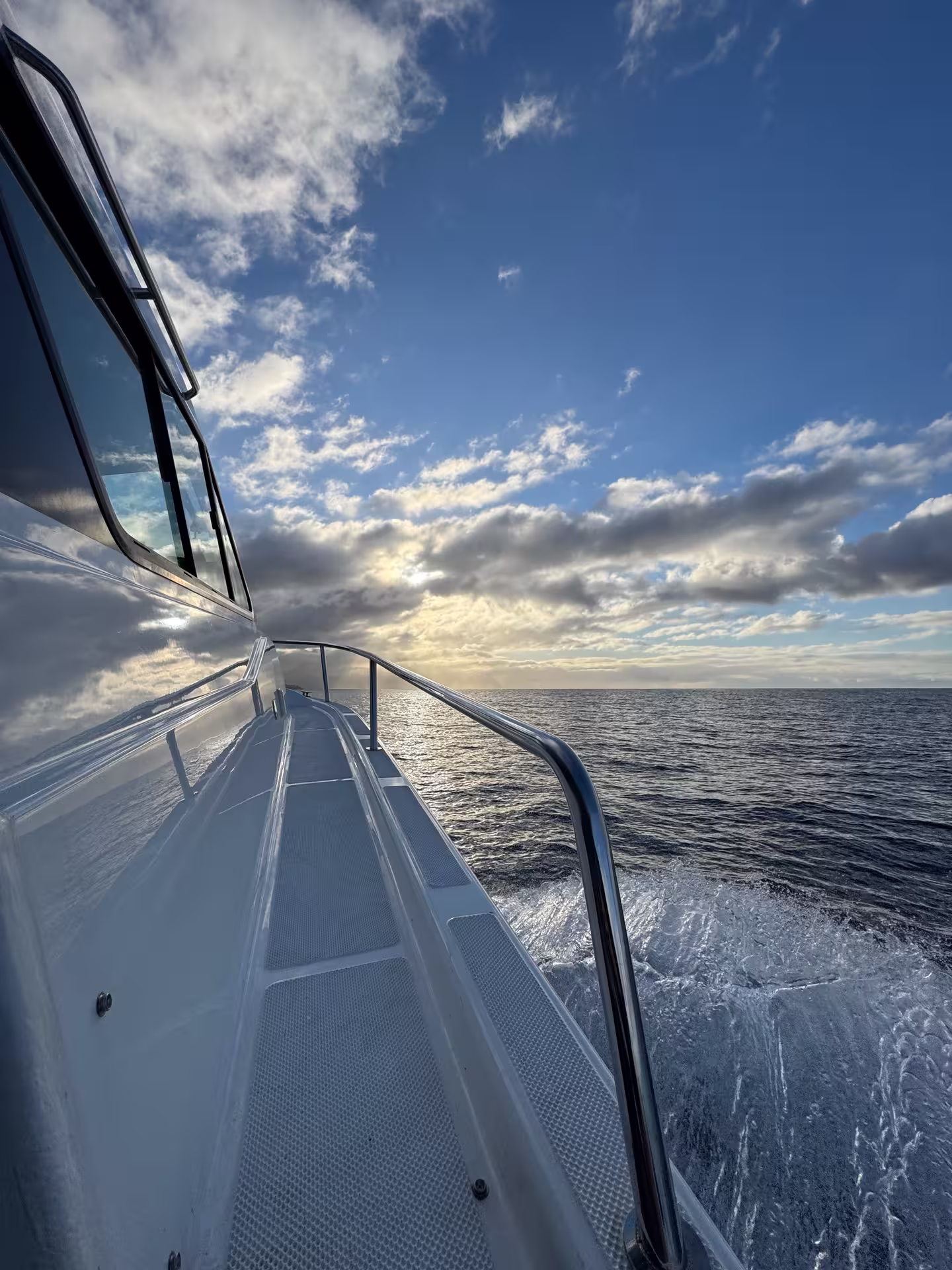 Scenic view from a yacht deck cruising towards Desertas Island under a picturesque sky, perfect for a serene ocean adventure.
