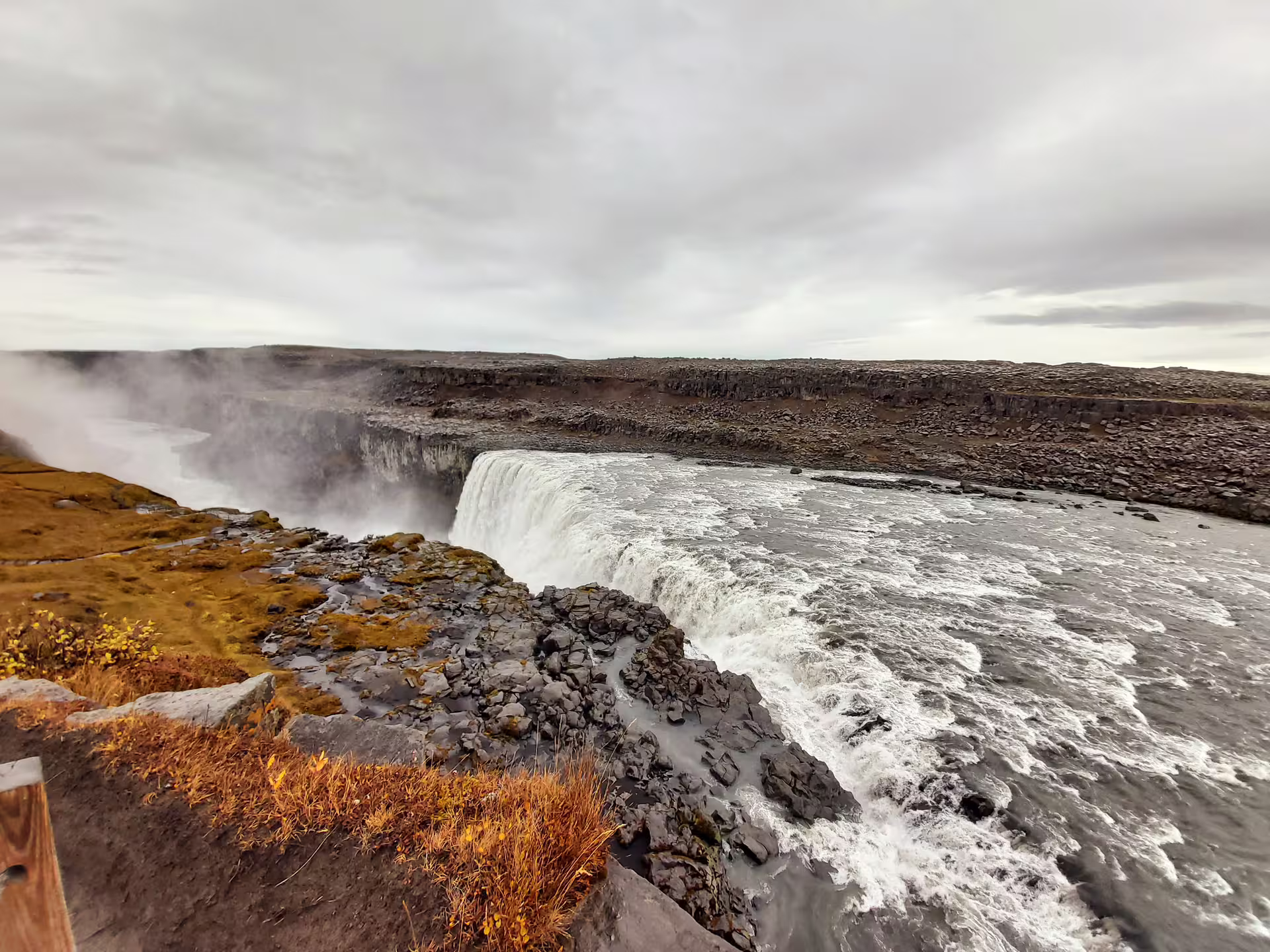 Powerful Dettifoss waterfall cascading into a rocky canyon with mist rising, Iceland