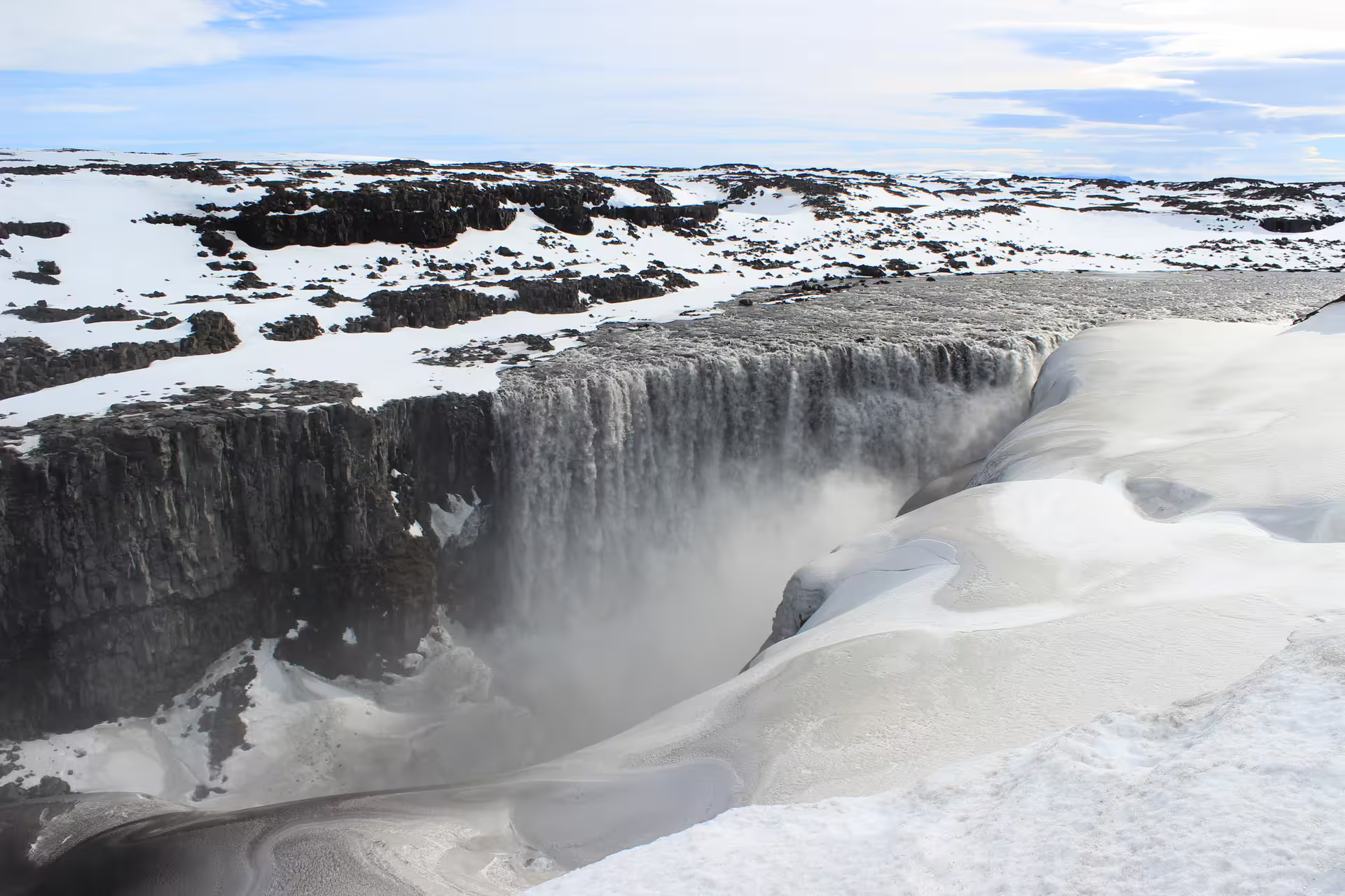 Dettifoss waterfall in Iceland surrounded by snow-covered volcanic landscape in winter