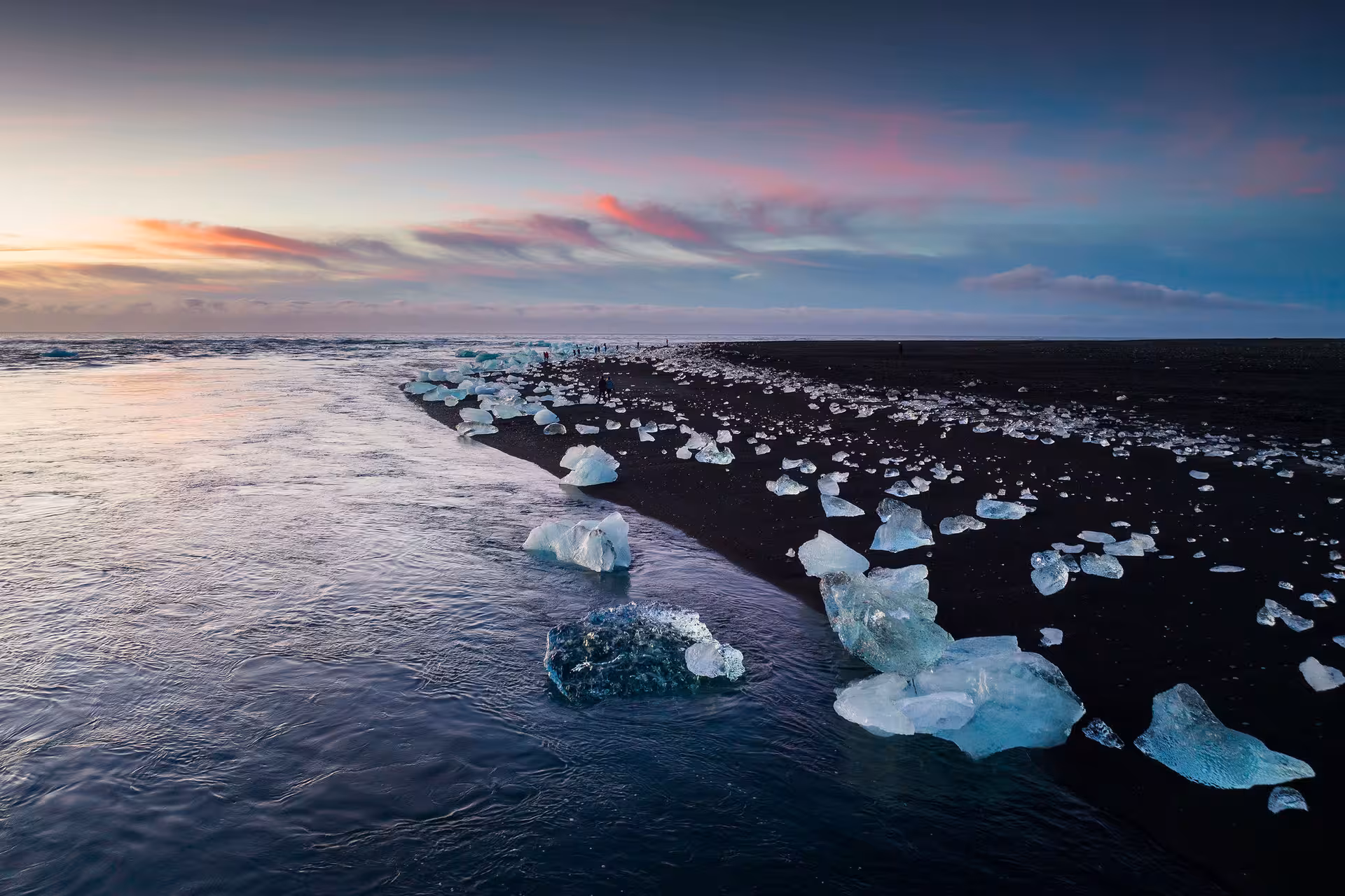 Ice chunks on black sand Diamond Beach near Jökulsárlón Glacier Lagoon at sunset, Iceland