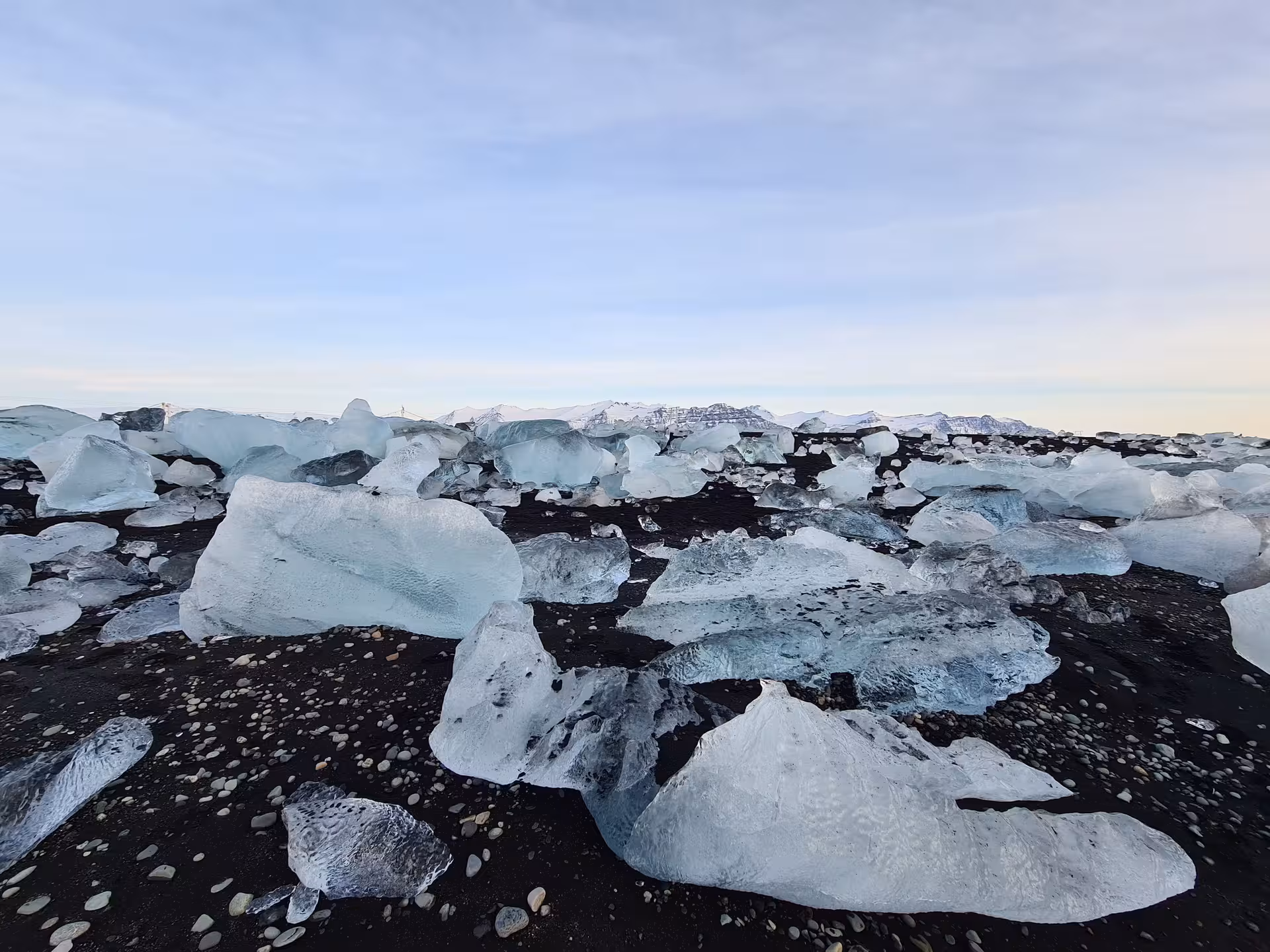 Ice chunks scattered on black sand Diamond Beach near Jokulsarlon glacier lagoon Iceland