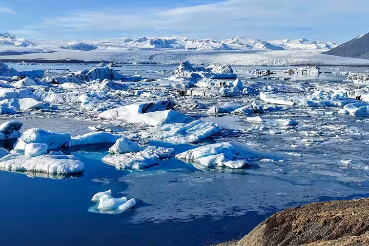 Floating icebergs on Jokulsarlon glacier lagoon with snow-capped mountains in Iceland