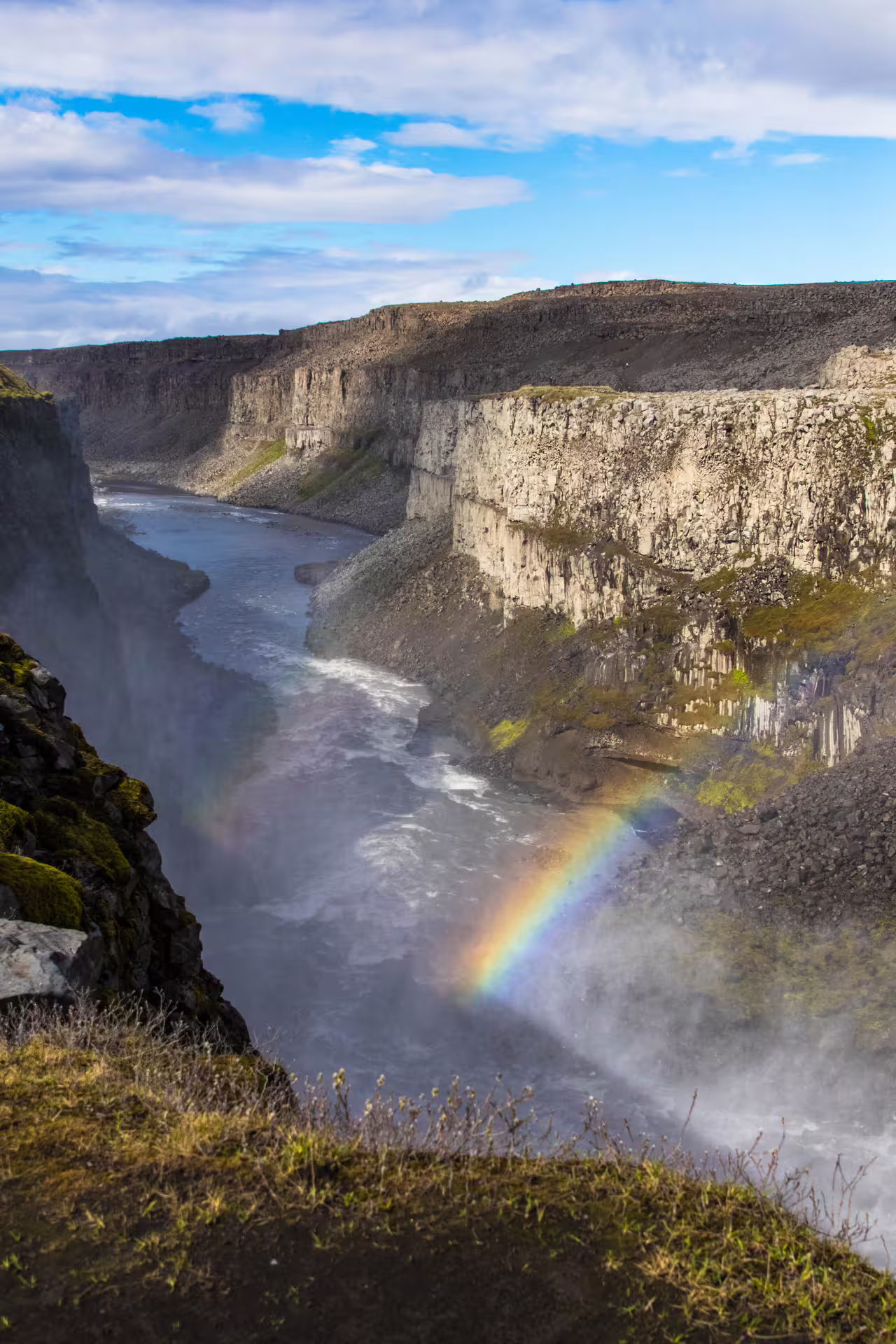 Rainbow over Jökulsárgljúfur canyon gorge with rushing river and mist in North Iceland