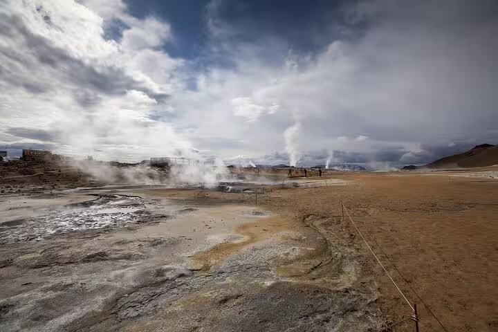 Geothermal steam vents and hot springs at Námafjall Hverir in North Iceland under cloudy sky