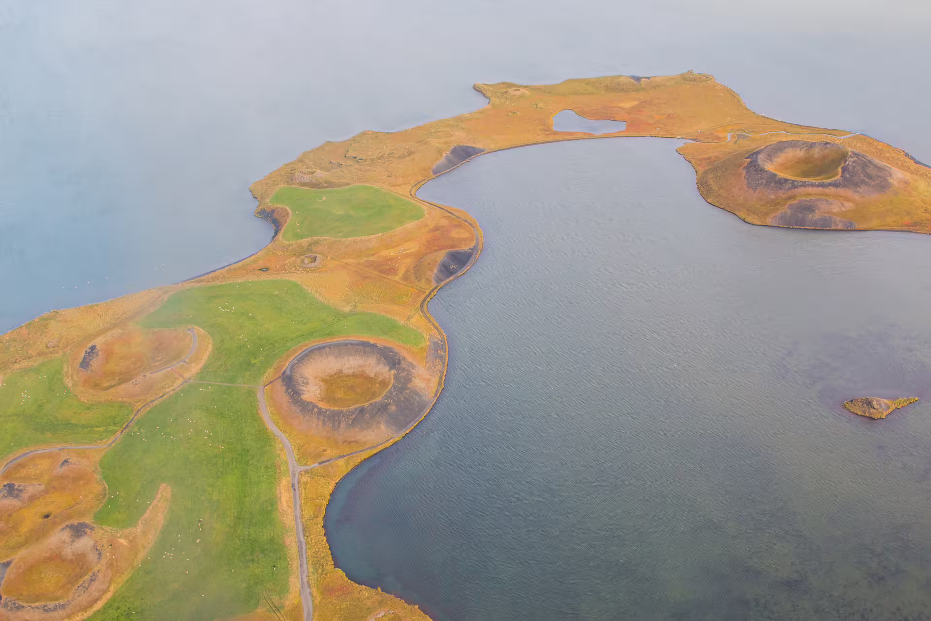 Aerial view of volcanic craters and lakeshore peninsula in North Iceland