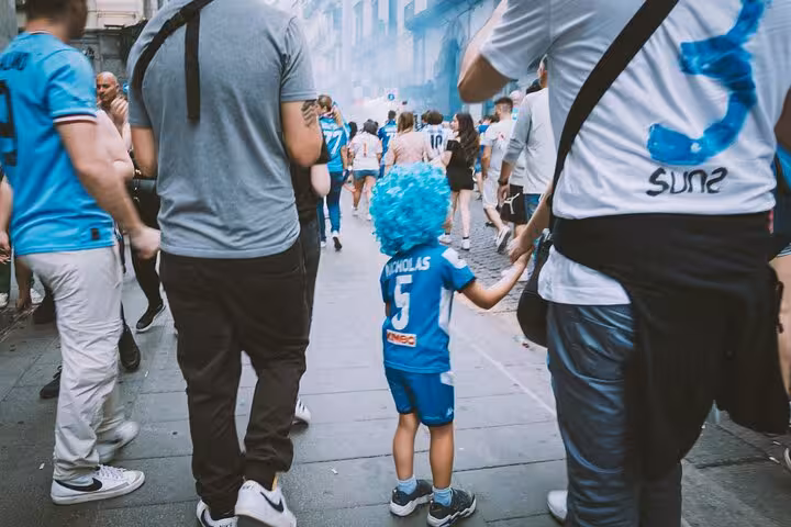 Naples street crowd with young Napoli fan, walking the Diego Maradona legacy tour of football culture and pizza