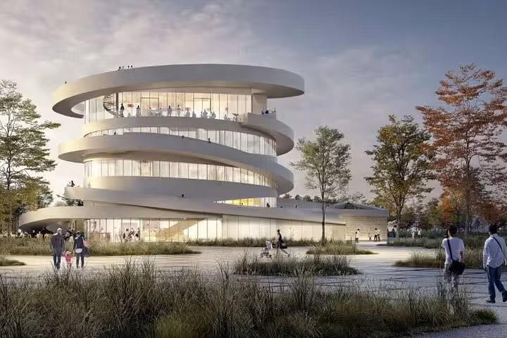 Modern spiral white building with wraparound balconies surrounded by trees and pedestrians at dusk