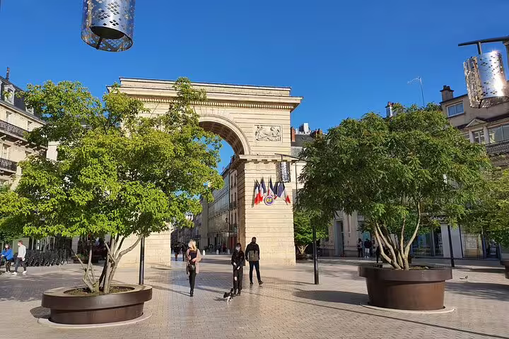 Porte Guillaume triumphal arch with French flags in Dijon city center pedestrian square