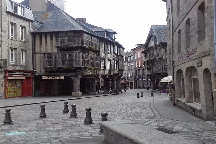 Medieval half-timbered buildings and cobblestone square in historic Dinan town center, Brittany, France
