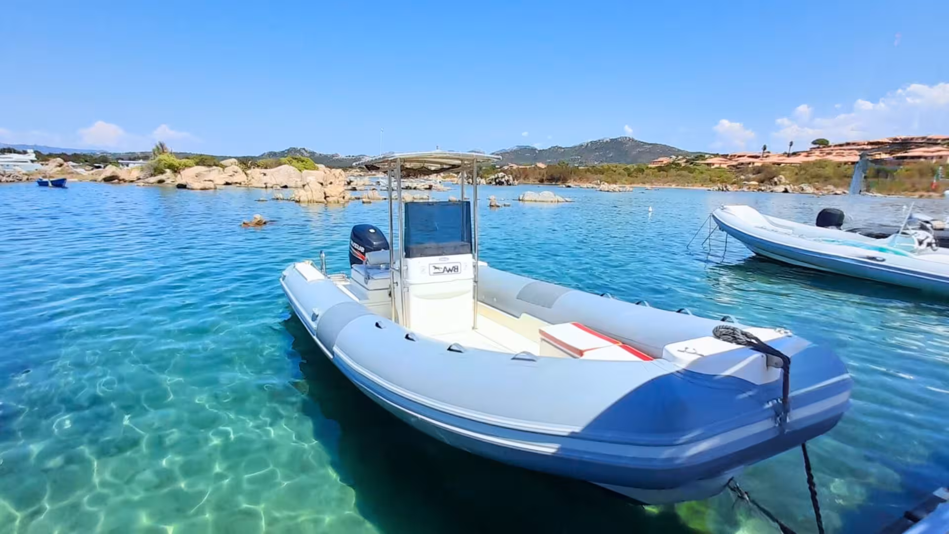 Dinghy moored in crystal-clear waters, ready for a Porto Cervo beach exploration tour from Porto Rotondo.