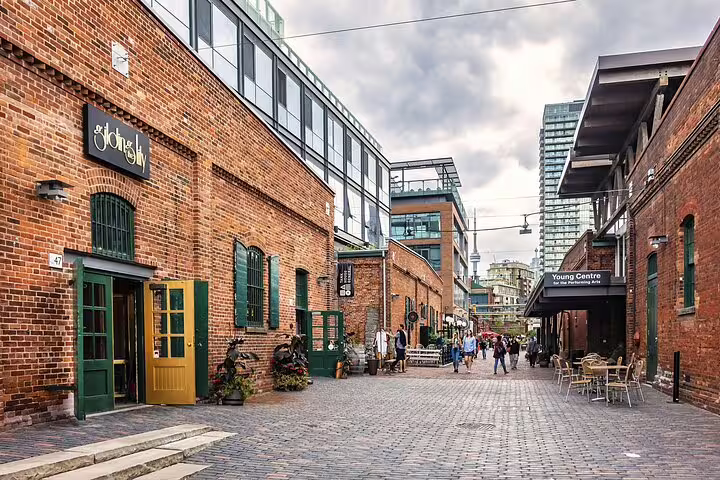 Cobblestone laneway in Toronto's Distillery District with historic red brick buildings and Young Centre for Performing Arts