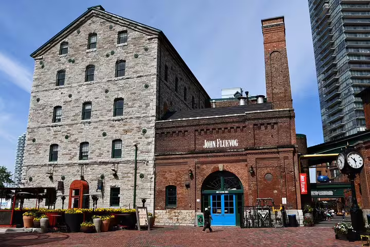 Historic stone and brick buildings of Toronto's Distillery District with John Fluevog store and clock tower
