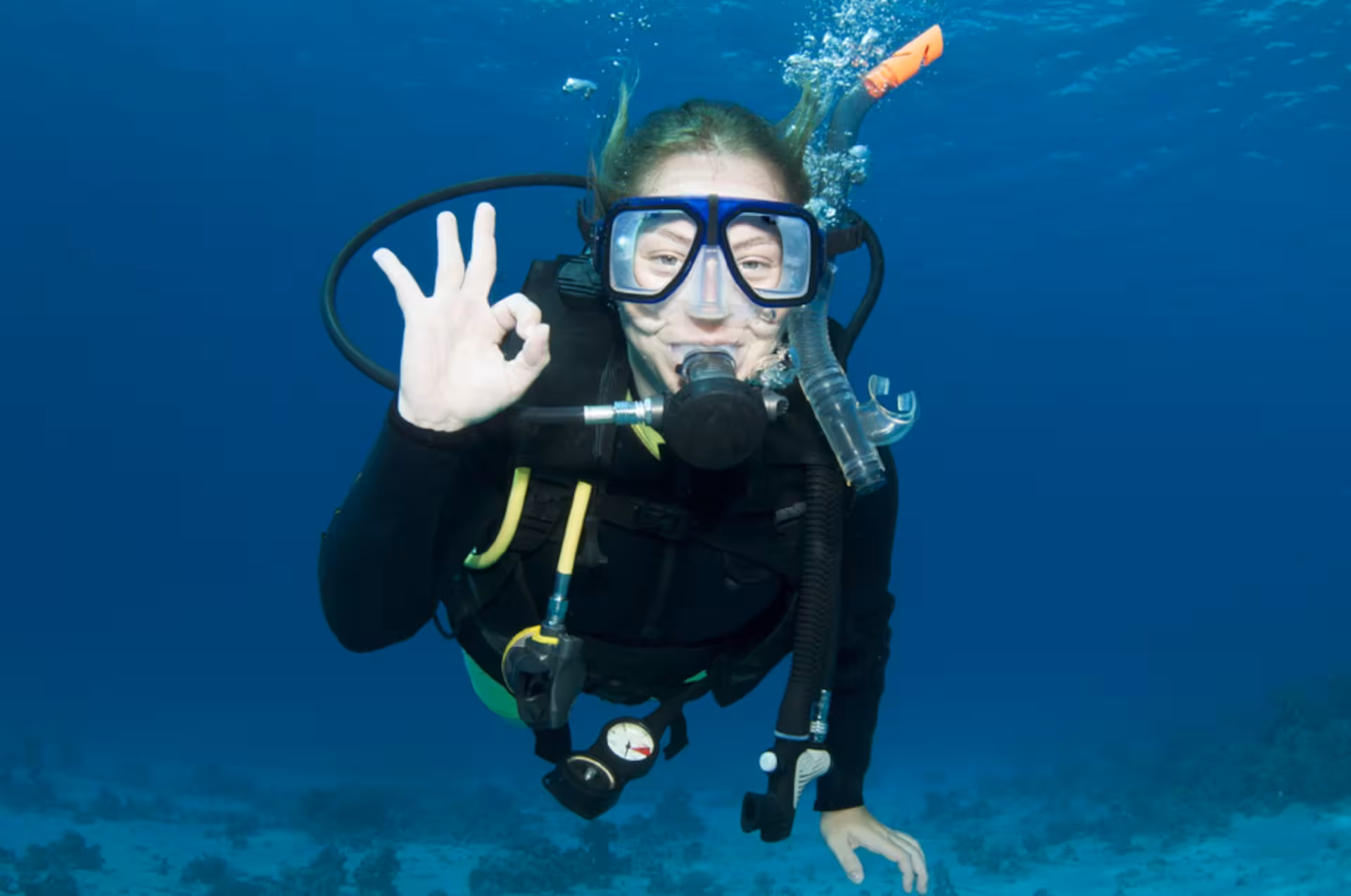 Diver signaling OK underwater at Ruja Island, enjoying a sea baptism experience from San Teodoro.