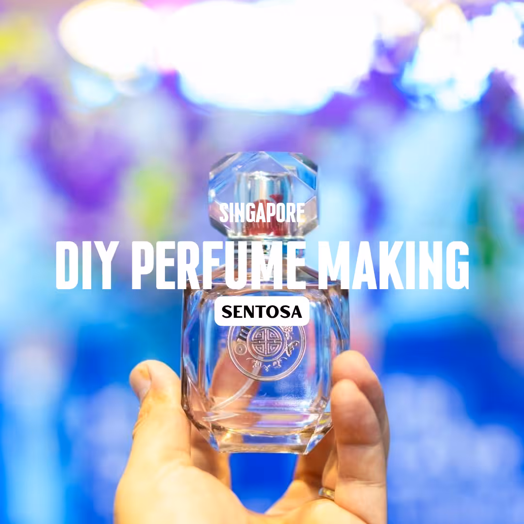 Hand holding a perfume bottle with vibrant background, promoting DIY Perfume Making experience in Sentosa, Singapore.