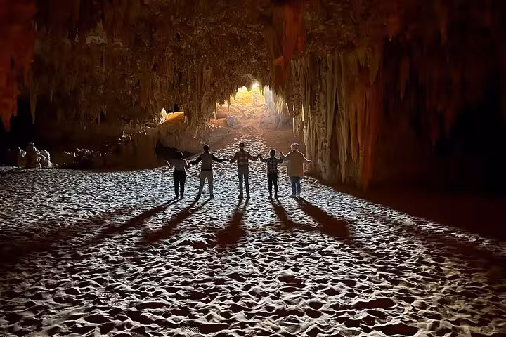 Group inside Djara Cave with dramatic light beams on 3-day White Desert and Black Desert camping safari Egypt