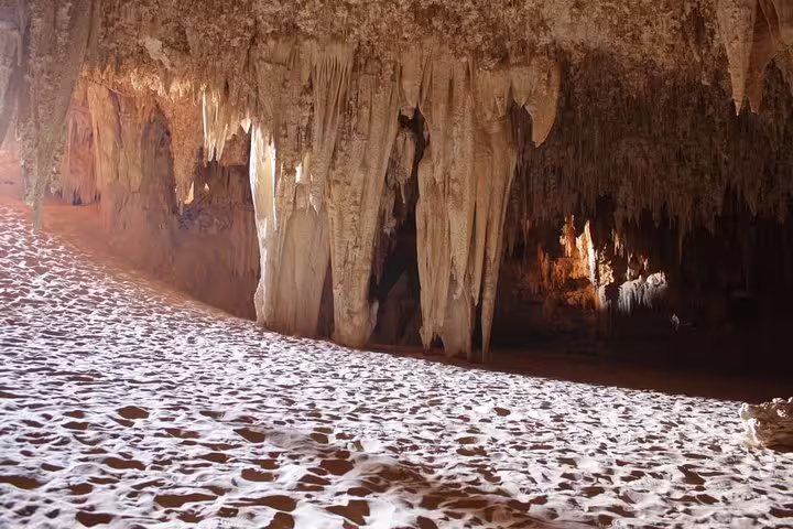 Djara Cave interior with stalactites and sandy floor, highlight of 5-day Egypt desert safari and camping package