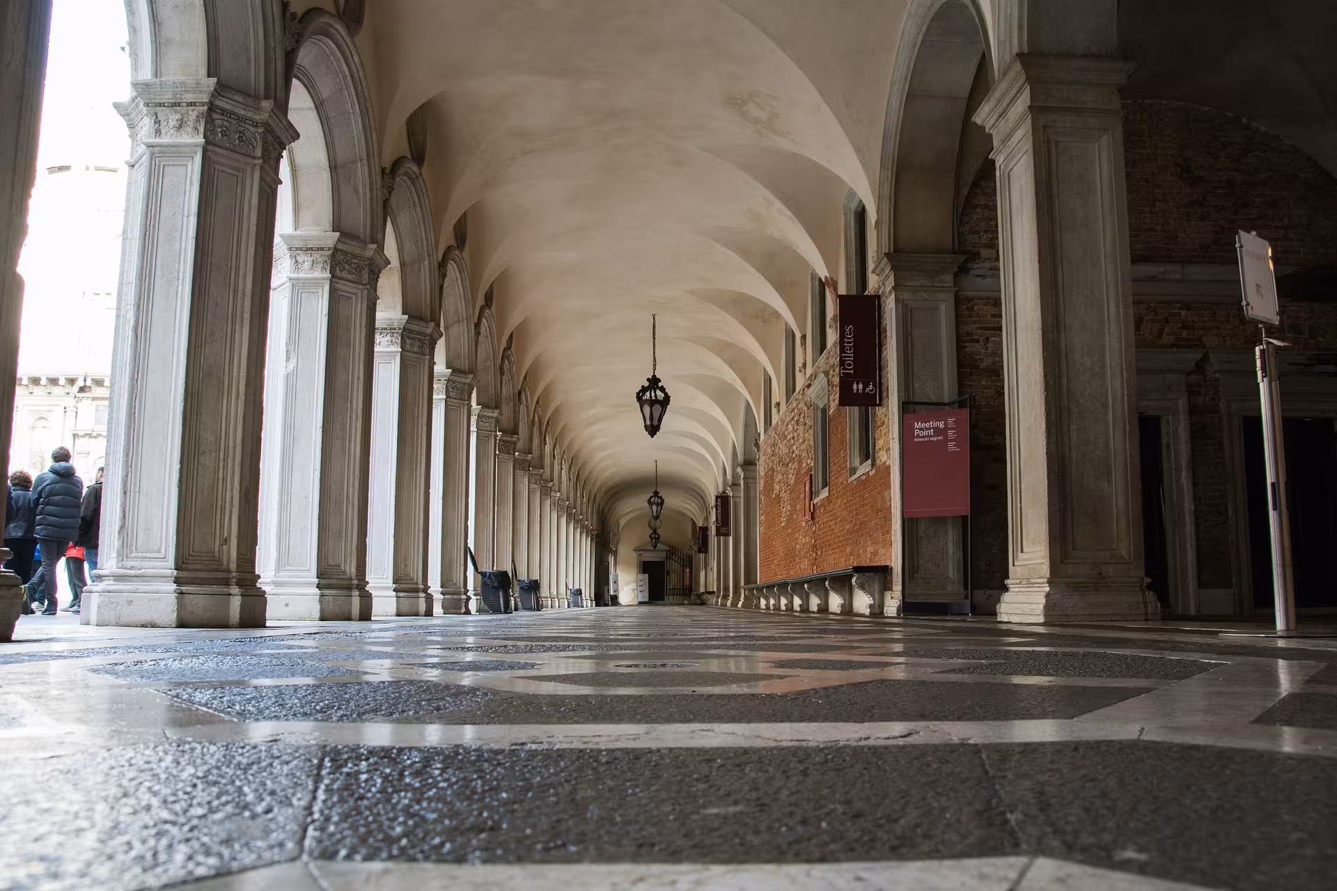 Elegant arched corridor with intricate columns in the Doge's Palace, capturing the essence of Venetian grandeur.