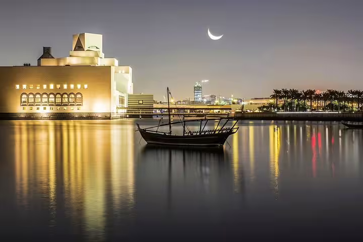 Night view of Doha skyline with crescent moon over Museum of Islamic Art and dhow boat on Doha Transit City Tour.