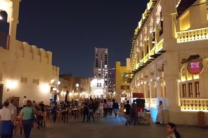 Lively evening scene at Souq Waqif in Doha, showcasing vibrant lights and bustling atmosphere on a city night tour.