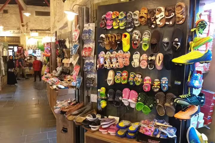 Colorful array of sandals and shoes displayed in a lively Doha market shop.