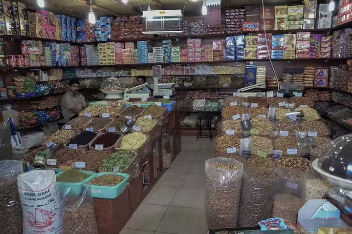 Explore a vibrant Doha market filled with diverse spices and colorful snacks, ideal for a private city tour itinerary.