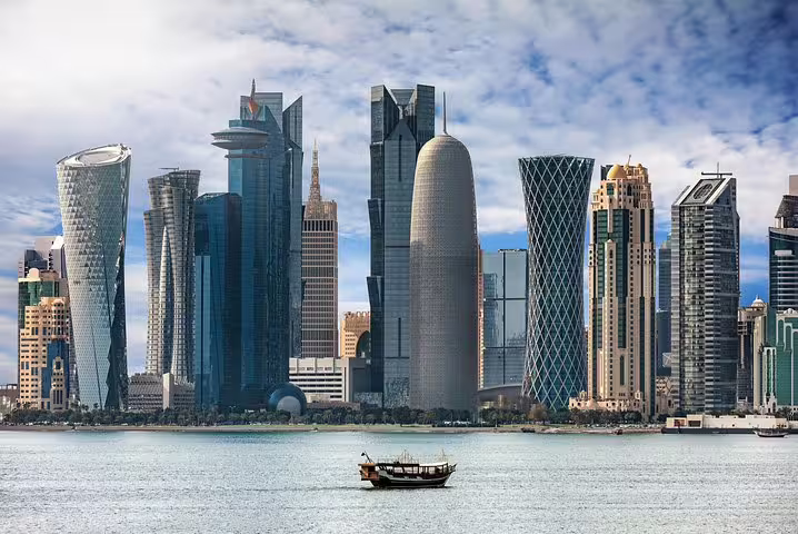 Traditional dhow boat sailing on Doha Bay with stunning skyline view, part of the Doha city tour experience.