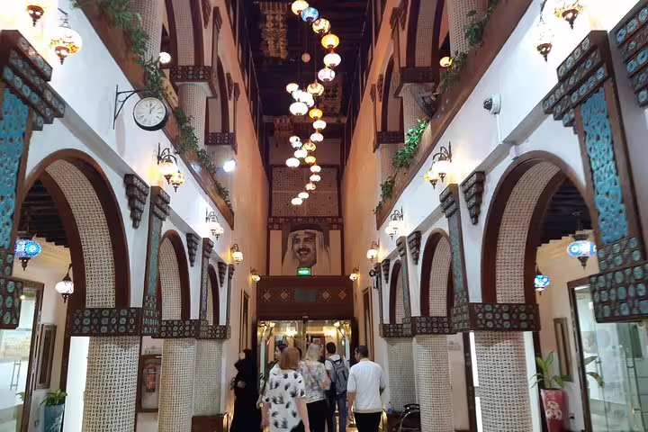 Visitors exploring a beautifully decorated corridor in a traditional Doha market with colorful lanterns and arches.
