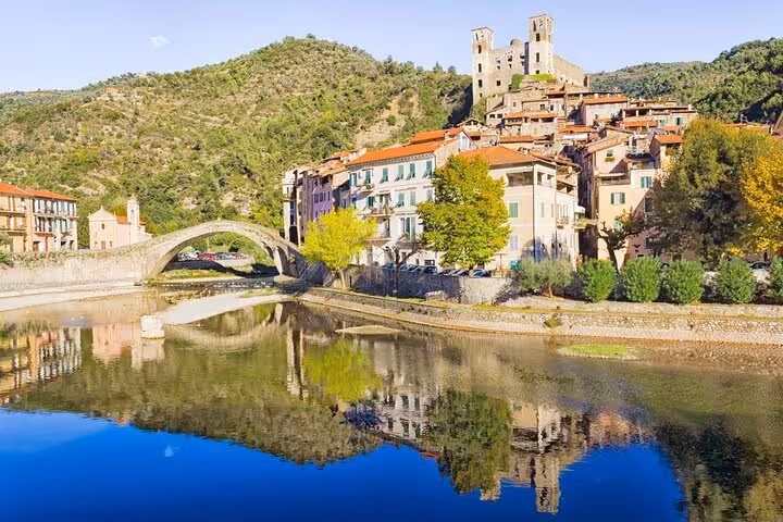 Medieval hilltop village of Dolceacqua with stone arch bridge reflecting in the Nervia River, Italian Riviera