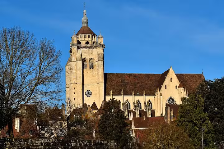 Collegiate Church of Dole with Gothic architecture and clock tower under blue sky, Dole France
