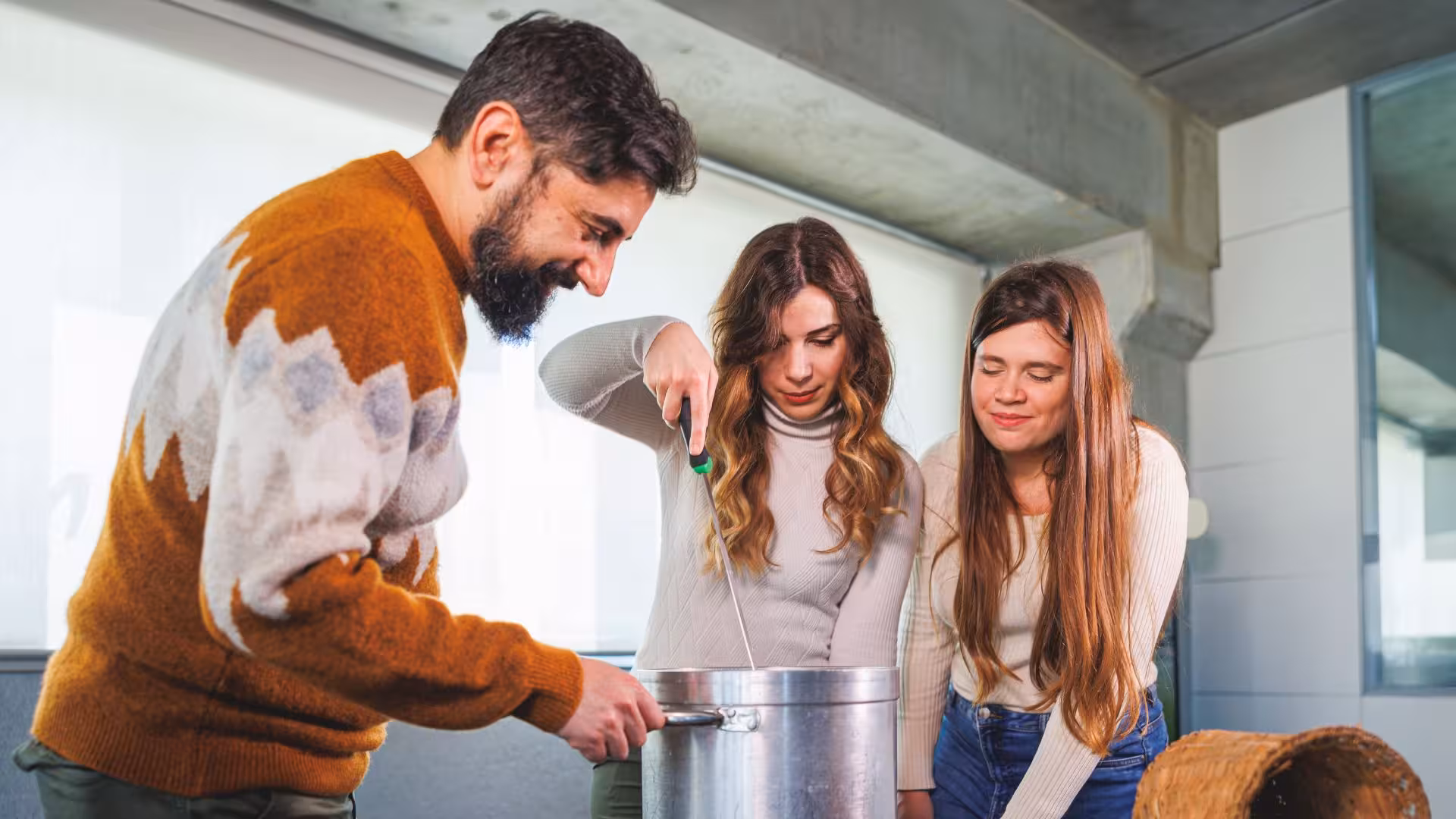 Group stirring cheese mixture in pot during interactive Dolianova cheese factory workshop.
