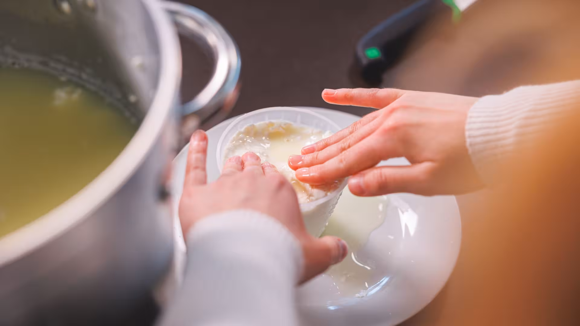 Hands shaping fresh cheese in a Dolianova workshop, highlighting interactive cheese-making experience.