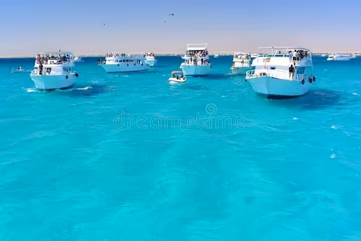 Tour boats on turquoise Red Sea at Dolphin House National Park, full-day snorkeling excursion from Hurghada