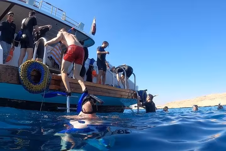 Guests boarding a snorkeling boat in Hurghada for Dolphin House dolphin swim tour with lunch in the Red Sea